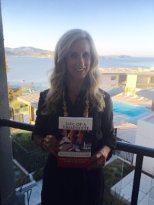 Meredith Kessler triathlete holding book Life of a Triathlete Race Preparation