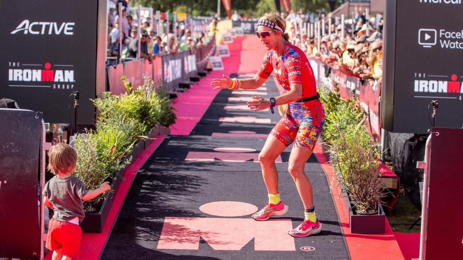 Meredith finishing strong and sharing a finish-line moment with a child