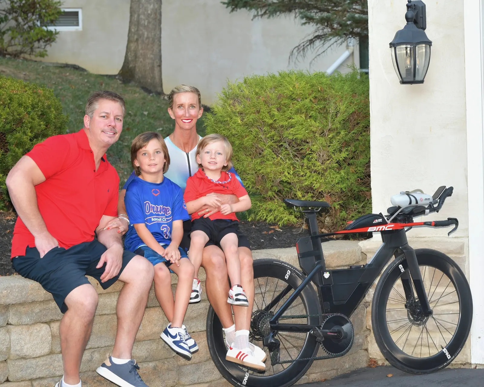 Meredith with Aaron, Mak, and Crew beside the triathlon bike