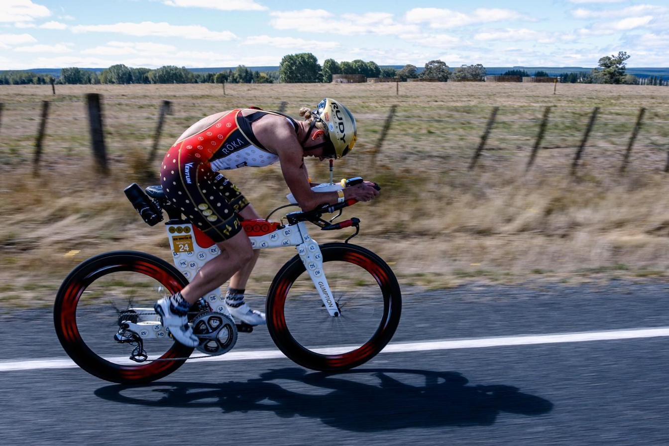 Meredith cycling in aero position on open road